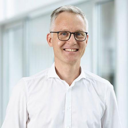 [Translate to Englisch:]   Portraitbild Dr. Markus Schrödel, lächelnd, Arzt der OCM Orthopädische Chirurgie München