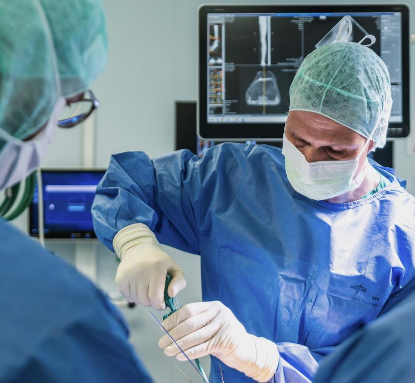 Arthroskopie Knie, Arzt in OP-Kleidung im Operationssaal, konzentriert bei der Arbeit
